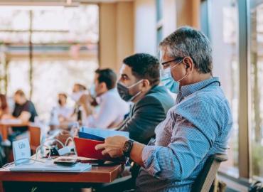 Man wearing a medical mask in a meeting