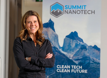 Amanda Hall smiling in front of a Summit Nanotech standing sign